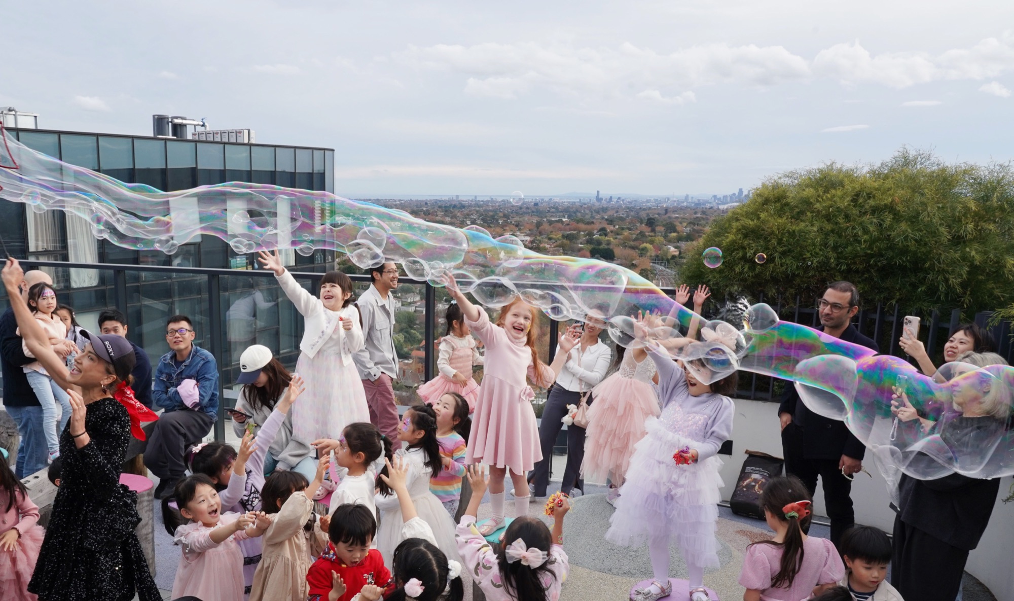 Giant bubble show entertaining guests at a rooftop party