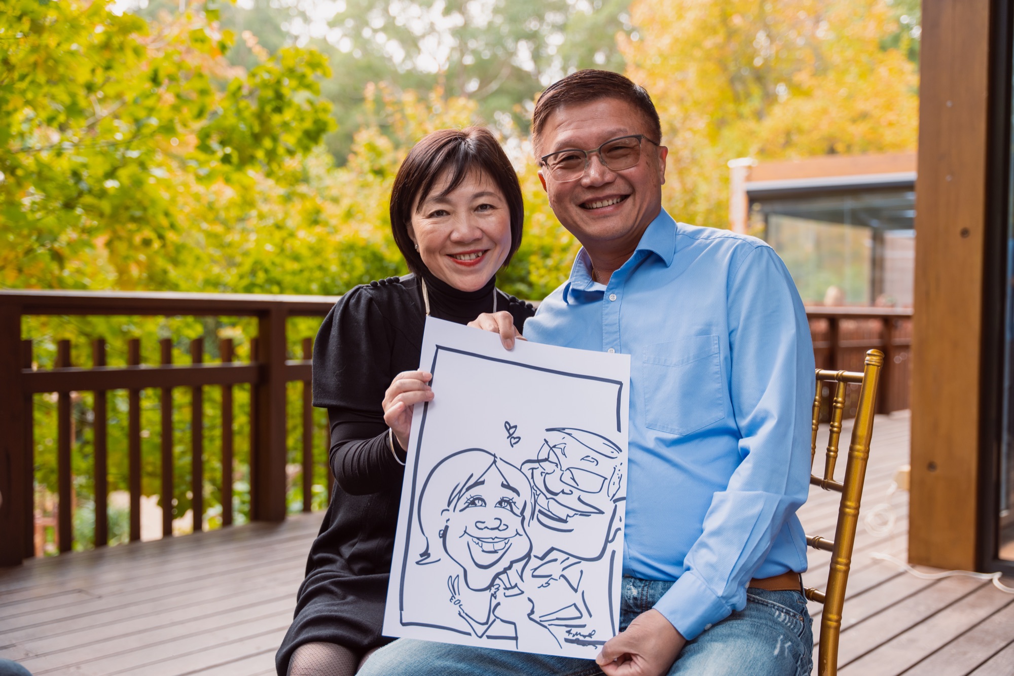 Guests holding a live caricature drawing at an outdoor celebration