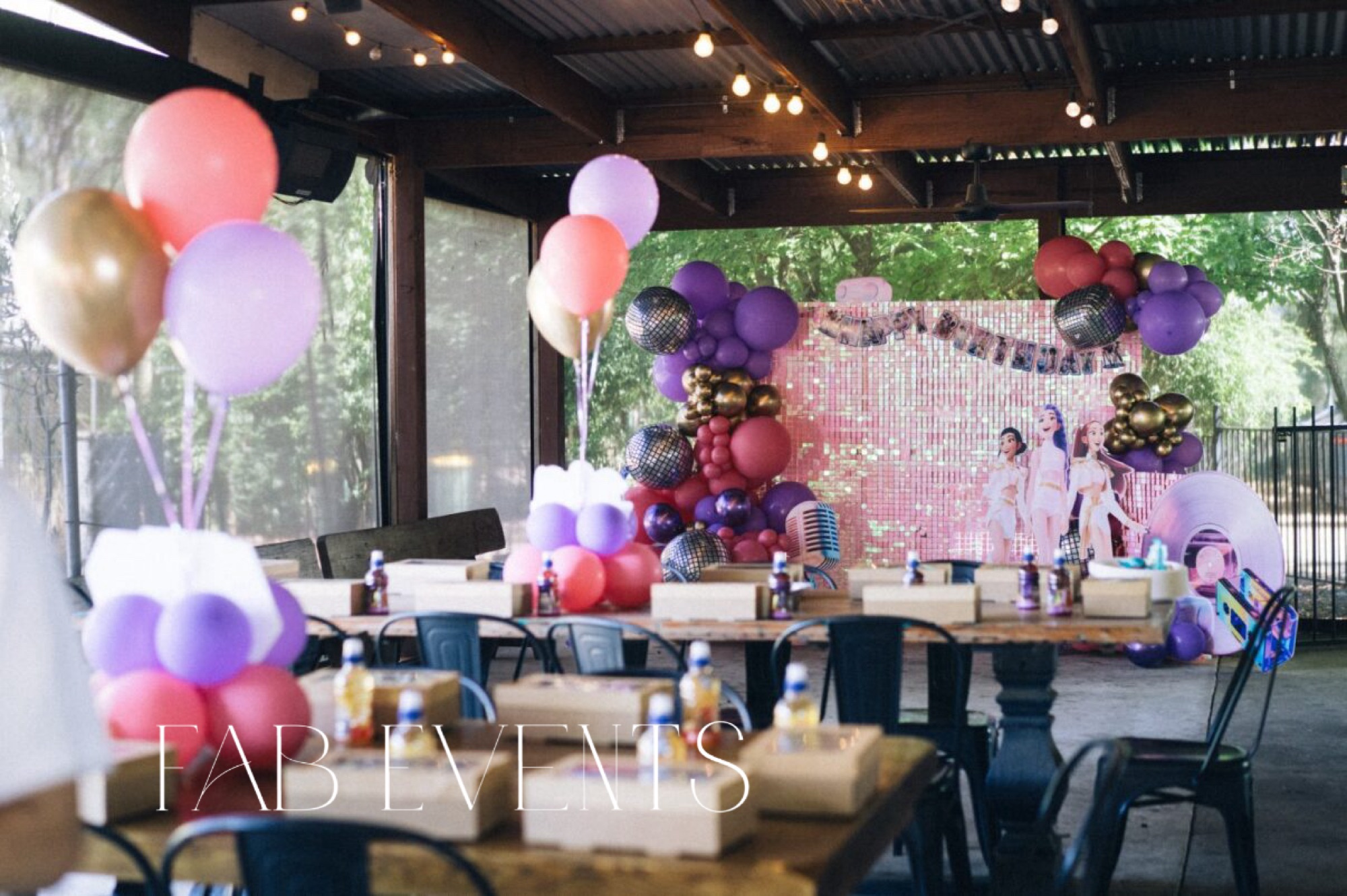 Purple and gold balloon garland styling an outdoor party venue